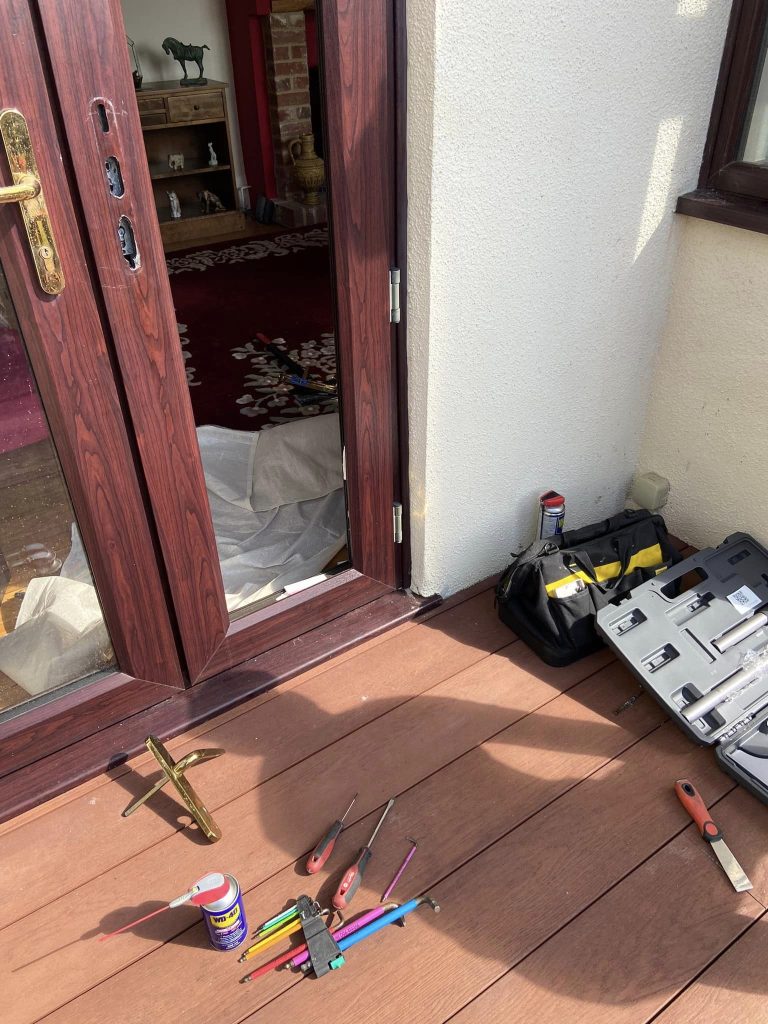 Patio door under repair with the locksmith specialist tools