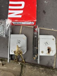 Two lock mechanisms side to side, the new one on the left and the failed lock mechanism on the right